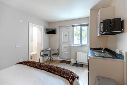 a bedroom with a bed and a kitchen with a sink at Windermere Studio Rooms - with Free Car Parking Onsite in Windermere
