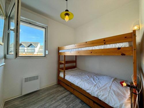 une chambre avec deux lits superposés et une fenêtre dans l'établissement Appartement 3 pièces à Carnac, balcon sud, proche plage - 4 pers - FR-1-377-14, à Carnac