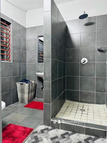 a bathroom with a shower with a red rug at Monavy Riverside Hotels in Tzaneen in Lenyenye