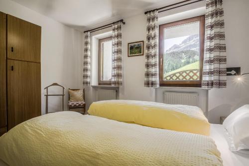 a bedroom with two beds and a window at Chalet Pradat in Arabba