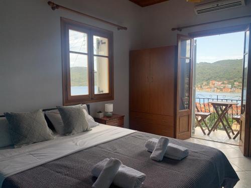 een slaapkamer met een groot bed en handdoeken bij Albatros rooms in Vathi
