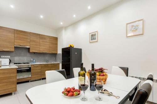 een keuken met een tafel met wijnflessen en een fruitschaal bij Premium 2 Bedroom Apartment lll in Tbilisi City