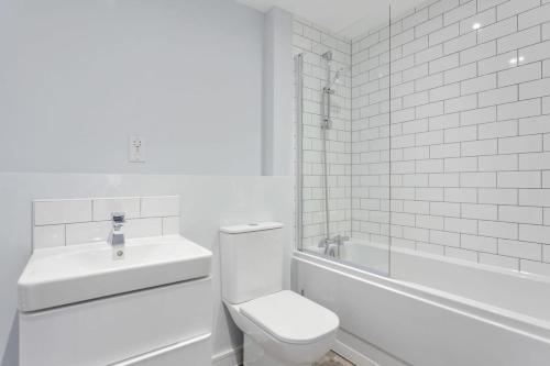 uma casa de banho branca com um WC e um lavatório em Modern & Spacious Apartment In Central Birmingham em Birmingham