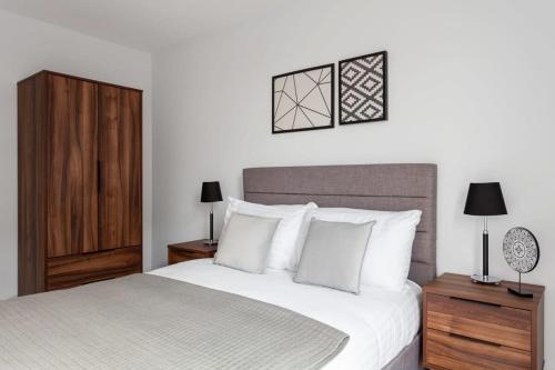 um quarto com uma cama grande e almofadas brancas em Modern & Spacious Apartment In Central Birmingham em Birmingham
