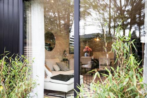 a patio with a white couch and a table at Veluwe Boutique Lodge in Putten