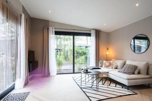 a living room with a white couch and a table at Veluwe Boutique Lodge in Putten