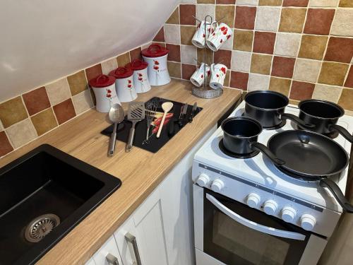 a kitchen with a stove with pots and pans on it at ElMurrs in Bournemouth