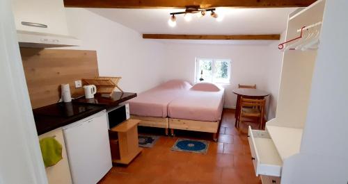 une petite chambre avec un lit et une table dans l'établissement Small Town House with private parking and access to garden, near Paris and all public transport, à La Courneuve