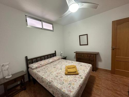 - une chambre avec un lit et une serviette jaune dans l'établissement Haro Beach San Juan, à El Campello