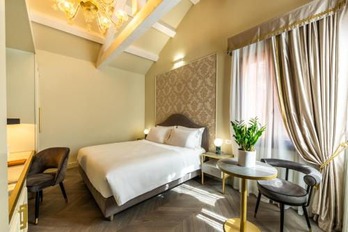 a hotel room with a bed and a table and chairs at Hotel Palazzina Sardi in Venice