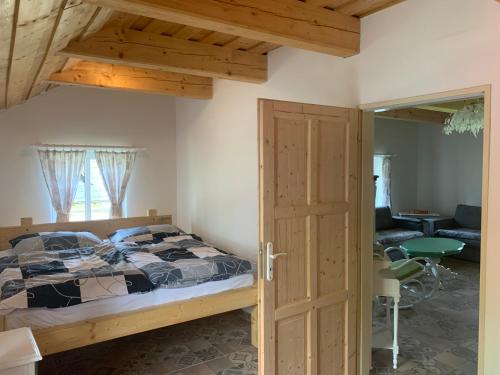 um quarto com uma cama e uma porta de madeira em chata-brdy em Nové Mitrovice