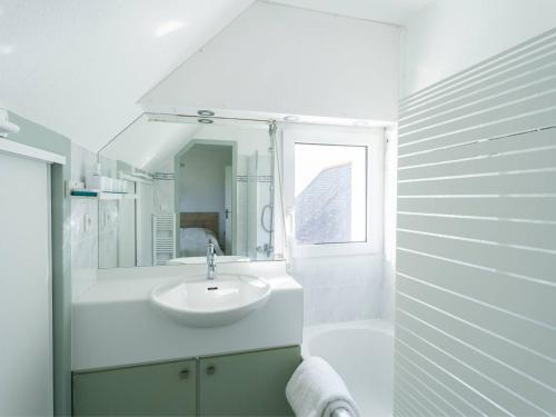 une salle de bain blanche avec un lavabo et un miroir dans l'établissement Carnac - Duplex 3 pièces avec piscine, proche plage et WiFi inclus - FR-1-477-212, à Carnac