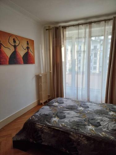 a bedroom with a bed and a painting on the wall at Joli appartement aux Eaux Vives in Geneva