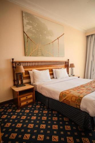 a hotel room with two beds and a picture on the wall at Umm Kulthum Hotel in Cairo