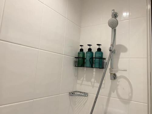 a bathroom with three bottles on a shelf in a shower at HNFC Stays - Prime Central Newcastle Studio w/ Gym+Free parking in Newcastle upon Tyne