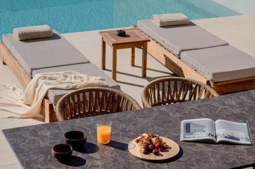 een tafel met een bord eten en een boek erop bij Anantia Villa 2 - Scenic View, Luxury Experience in episkopi-heraklion