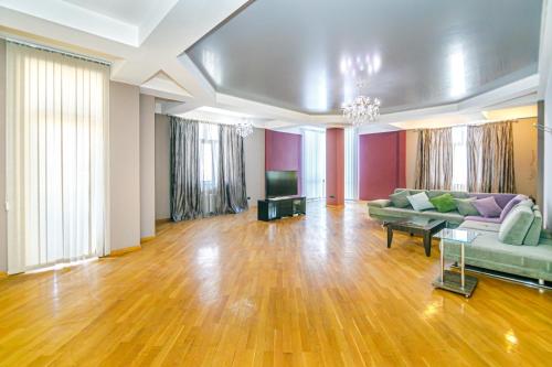 a large living room with a couch and a tv at Deluxe Apartment 142/59 in Baku