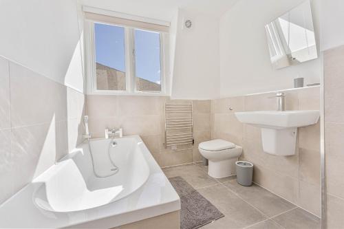 y baño con bañera, lavabo y aseo. en The Residence by Guestz, en Cheltenham