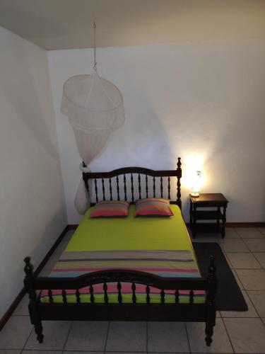 a bedroom with a bed with a green blanket at MO TI KOTÉ in Cayenne