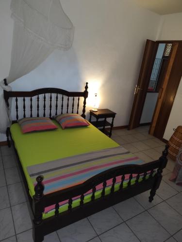 a bedroom with a large bed with a wooden frame at MO TI KOTÉ in Cayenne