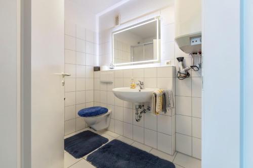 a bathroom with a sink and a toilet and a mirror at Ferienwohnung Rheinblick in Küssaberg