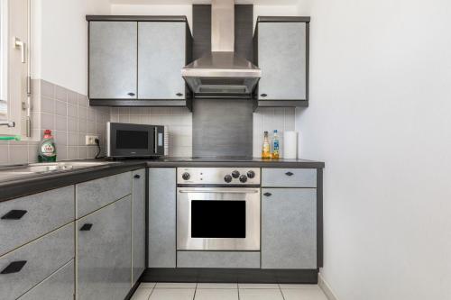 a kitchen with a stove and a microwave at Ferienwohnung Rheinblick in Küssaberg
