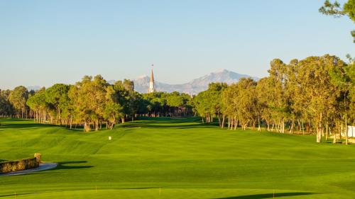 a view of a golf course with mountains in the background at Kaya Belek in Belek