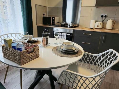 a kitchen table with a basket of food and wine glasses at Homely one bed apartment on main road with easy access to city or Peak District in Heeley