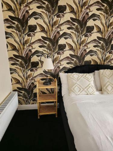 a bedroom with a bed and a table with a lamp at Homely one bed apartment on main road with easy access to city or Peak District in Heeley