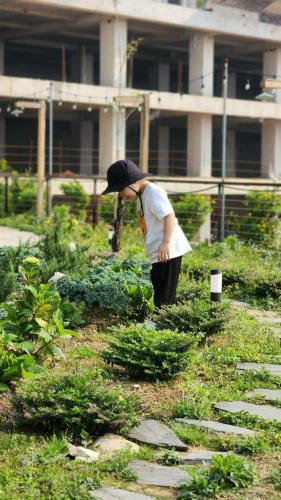 a woman standing in a garden with an umbrella at Sapa Yen Hotel in Sa Pa