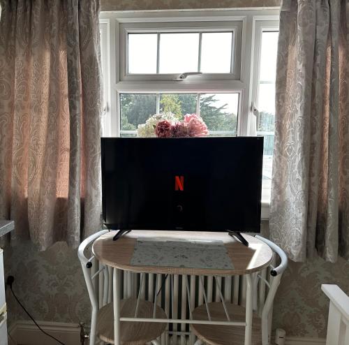 a computer monitor sitting on a table in front of a window at ElMurrs in Bournemouth