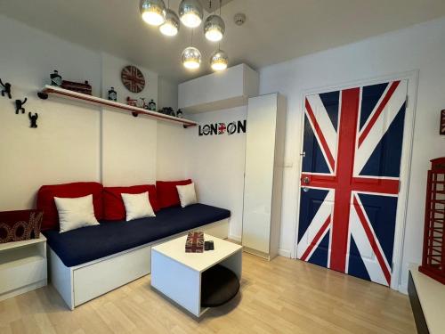 a living room with a couch and a flag on the wall at London Eyes in Ban Huai Luk (1)