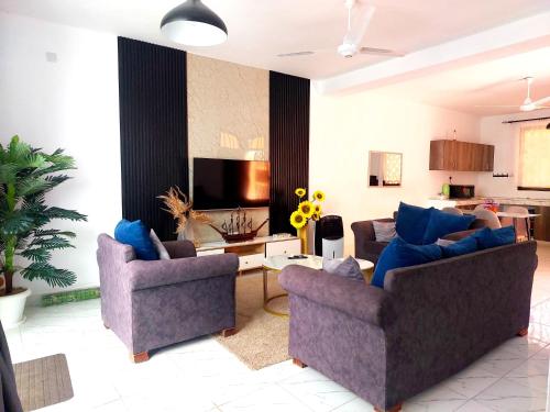 a living room with two couches and a tv at Jamiitown Homes in Kilifi