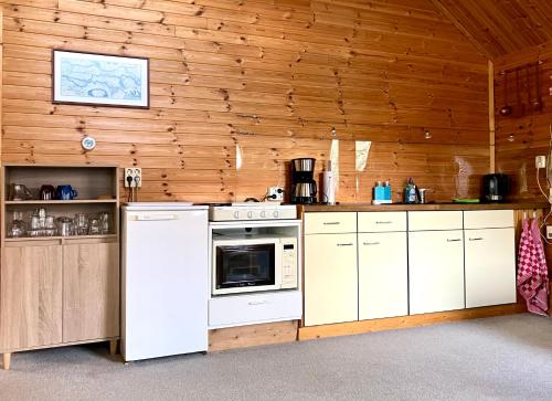 a kitchen with white appliances and a wooden wall at Waerdenhoeve in Waardenburg