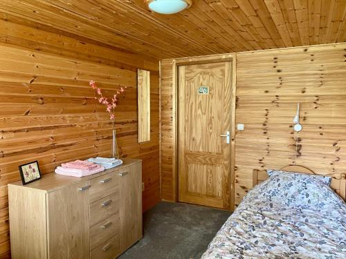 1 dormitorio con 1 cama y pared de madera en Waerdenhoeve, en Waardenburg