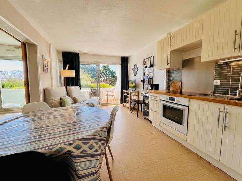 une cuisine et un salon avec une table et une salle à manger dans l'établissement Appartement T2 à Quiberon - 40m² avec Piscine, Tennis et Parking Privé, proche Plage et Commerces - FR-1-478-281, à Quiberon