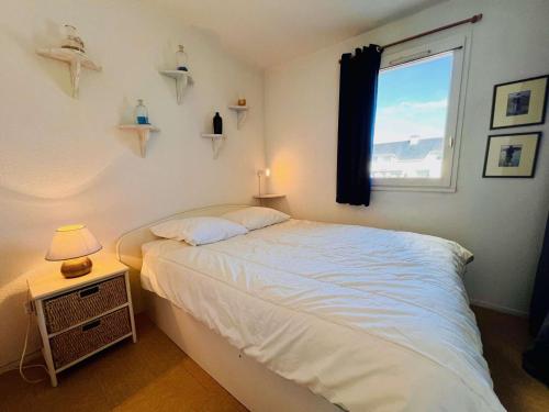 une chambre avec un lit blanc et une fenêtre dans l'établissement Appartement T2 à Quiberon - 40m² avec Piscine, Tennis et Parking Privé, proche Plage et Commerces - FR-1-478-281, à Quiberon