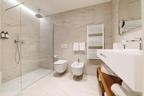 a bathroom with a shower and a toilet and a sink at THE ONE CAORLE - Hotel & Apartments in Caorle