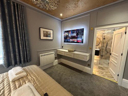 a bedroom with a bed and a tv on the wall at Swish Luxury Holiday Apartments in Blackpool