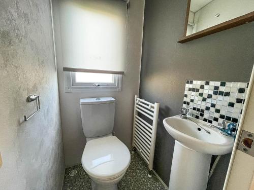 La petite salle de bains est pourvue de toilettes et d'un lavabo. dans l'établissement Lovely 8 Berth Caravan At California Cliffs Nearby Scratby Beach Ref 50060e, à Great Yarmouth