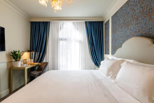 a bedroom with a large white bed with a blue wall at Hotel Palazzina Sardi in Venice