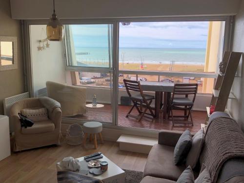 - un salon avec un canapé et une table offrant une vue sur la plage dans l'établissement Studio - MARINA 6, à Saint-Jean-de-Monts