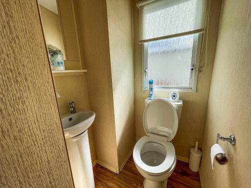 a small bathroom with a toilet and a sink at 8 Berth Caravan At Dovercourt Holiday Park In Essex Ref 44002p in Great Oakley