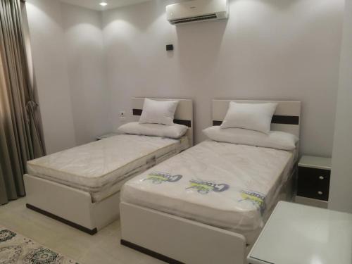 duas camas num pequeno quarto com saias em Marvel apartment em El Quseir