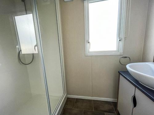 a bathroom with a sink and a glass shower door at Lovely 6 Berth, Dog Friendly Caravan For Hire In Norfolk Ref 50011ae in Great Yarmouth