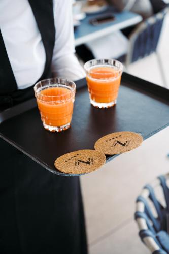 two glasses of orange liquid on a black table at THE ONE CAORLE - Hotel & Apartments in Caorle
