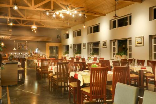 a restaurant with tables and chairs in a room at Hotel SunGrace in Mussoorie