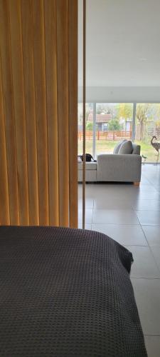 a bedroom with a bed and a window with a couch at Lamerced in Mar de Cobo