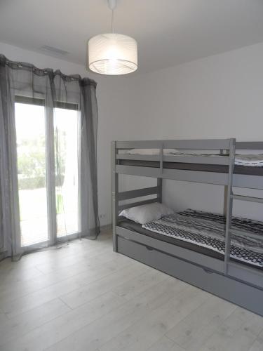 une chambre avec deux lits superposés et une fenêtre dans l'établissement St Cyprien Charmante maison proche du port et des plages, à Saint-Cyprien