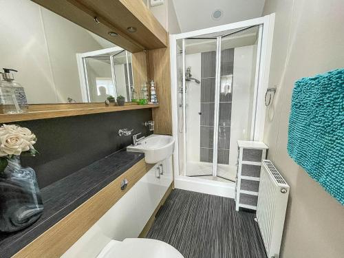 a bathroom with a toilet and a sink and a shower at Beautiful 6 Berth Caravan With Decking At Dovercourt Park, Essex Ref 44009g in Great Oakley